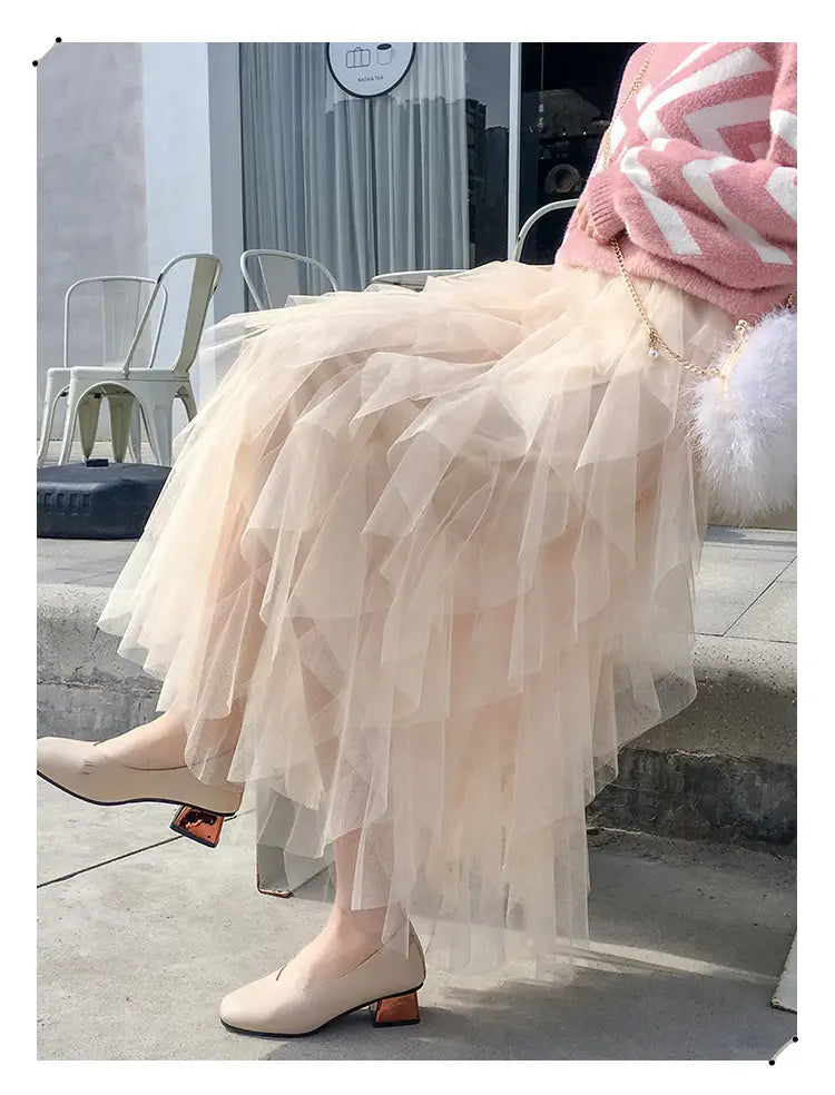 A flowing blush pink multi-layered tulle skirt with a ruffled hemline featuring easy matching mesh stitching details.
