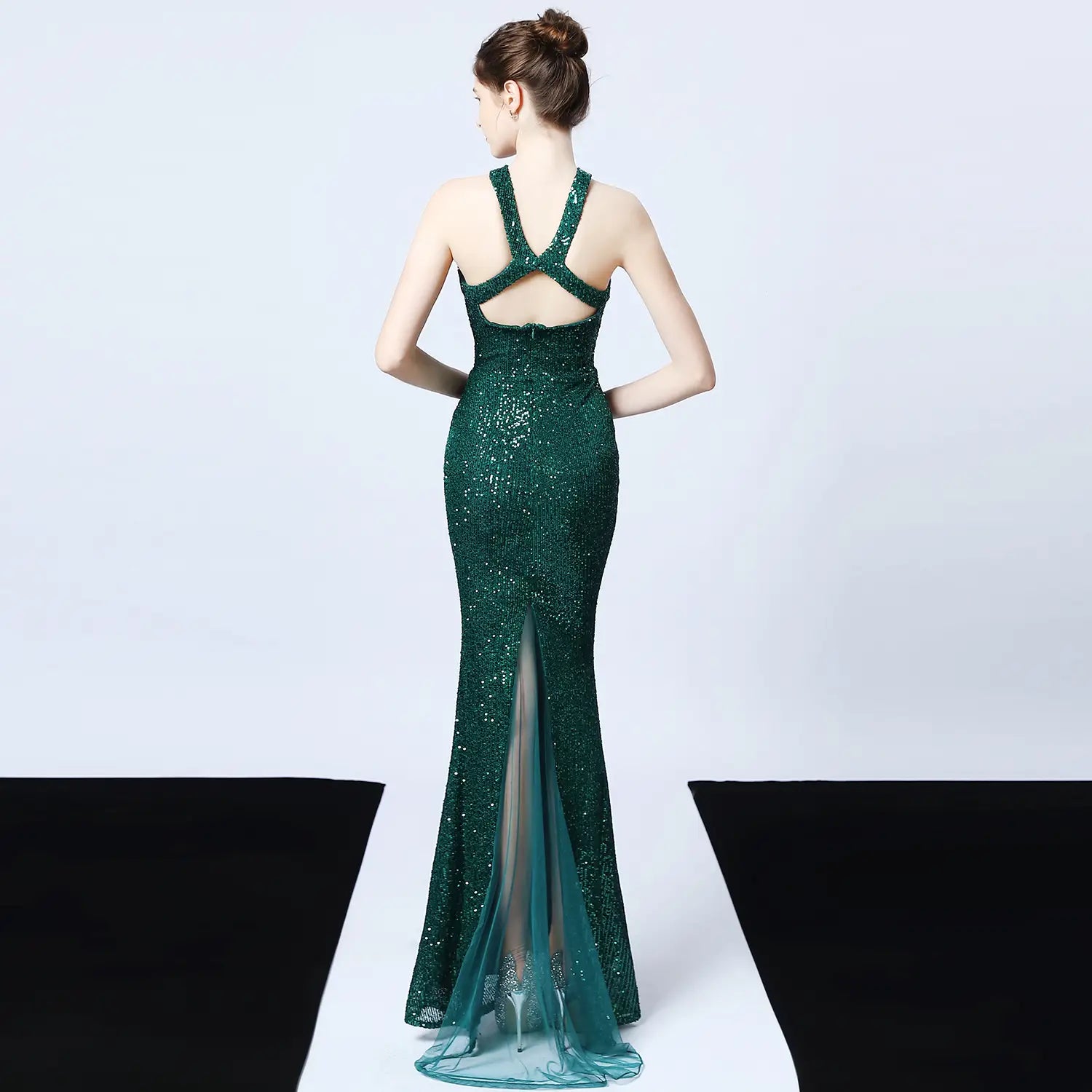 emerald green sequined mermaid gown with a backless design and sheer train made of polyester fiber showcasing long skirt length as the main fabric detail
