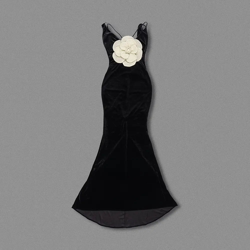 black camisole backless slim fit velvet floral gown featuring a black velvet mermaid silhouette with a prominent white floral embellishment at the bodice