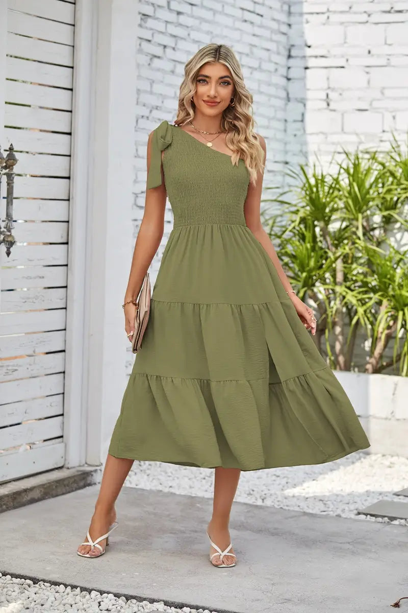 olive green tiered midi dress with one shoulder design and smocked bodice featuring a pleated layered hem and hem split dress detail