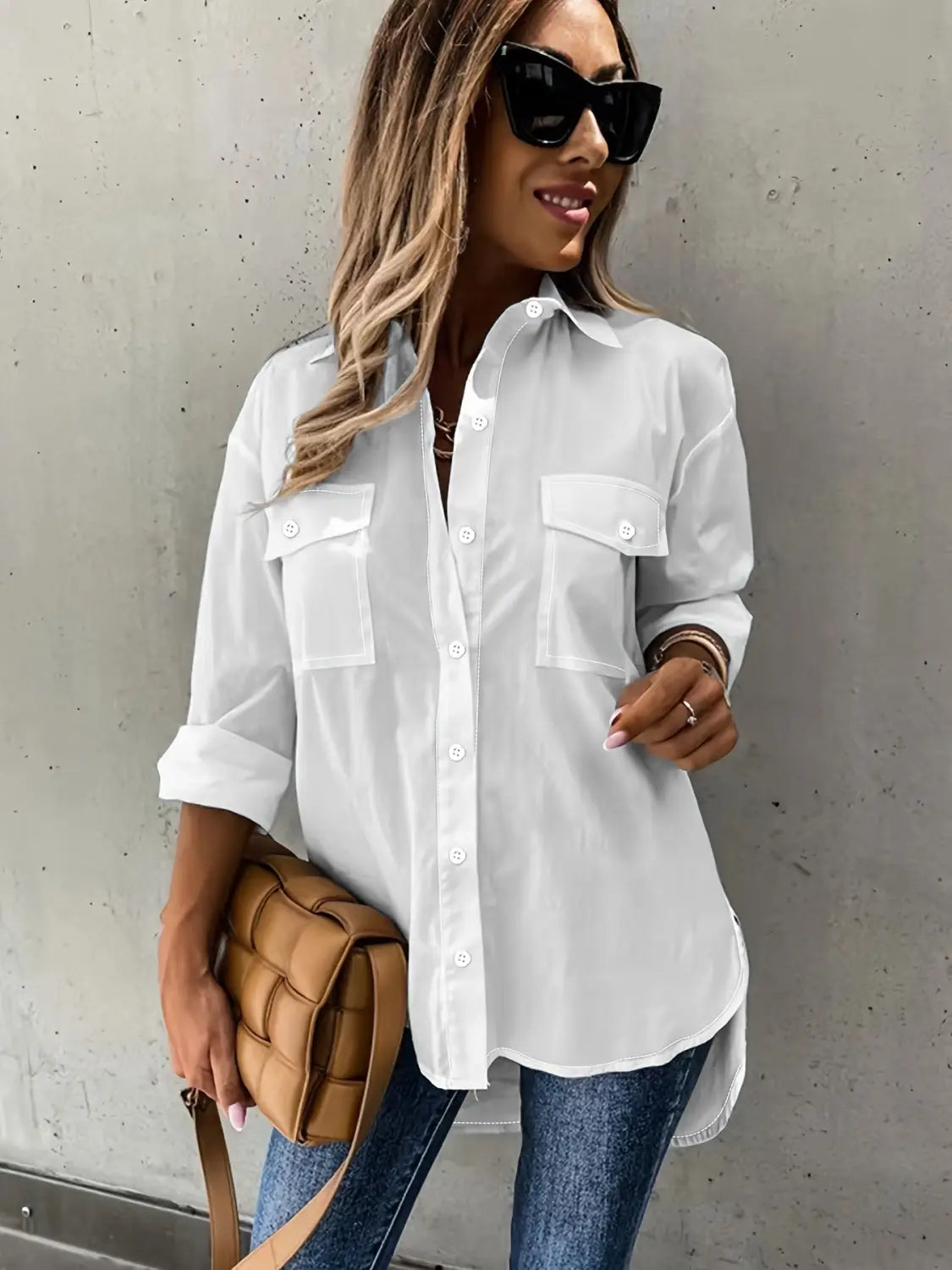 white button-up shirt with two front pockets and rolled sleeves showcasing a loose long sleeve design suitable for casual and formal wear