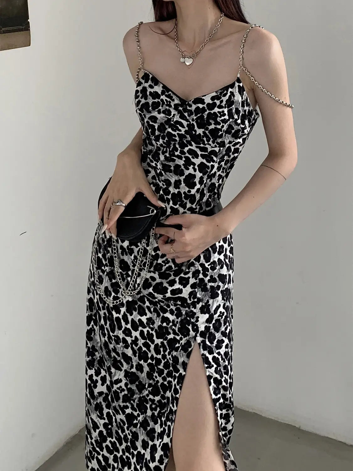 black and white leopard print satin slip dress with thin gold chain shoulder straps featuring a sexy leopard print design