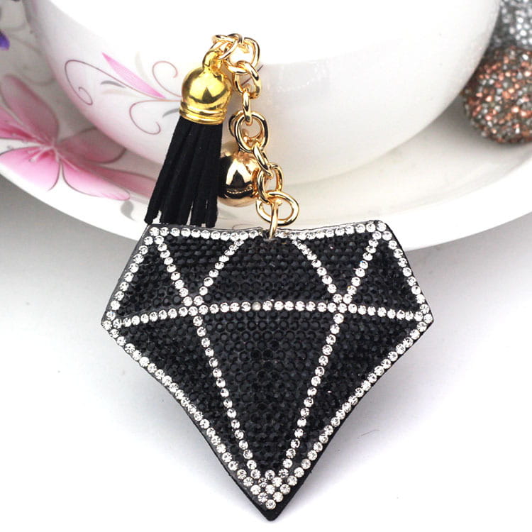 Black diamond-shaped bag pendant adorned with sparkling rhinestones and a gold-toned chain tassel and bell designed as a creative tassel women’s accessory.