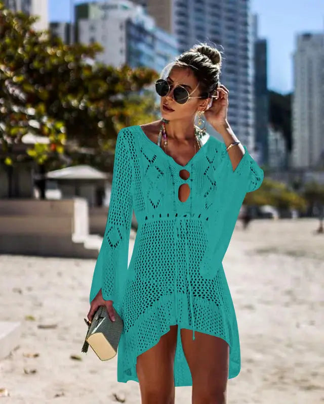 A turquoise long-sleeved crochet cover-up dress with a v-neck and keyhole cutouts designed as a women swimsuit cover up for bikini women.