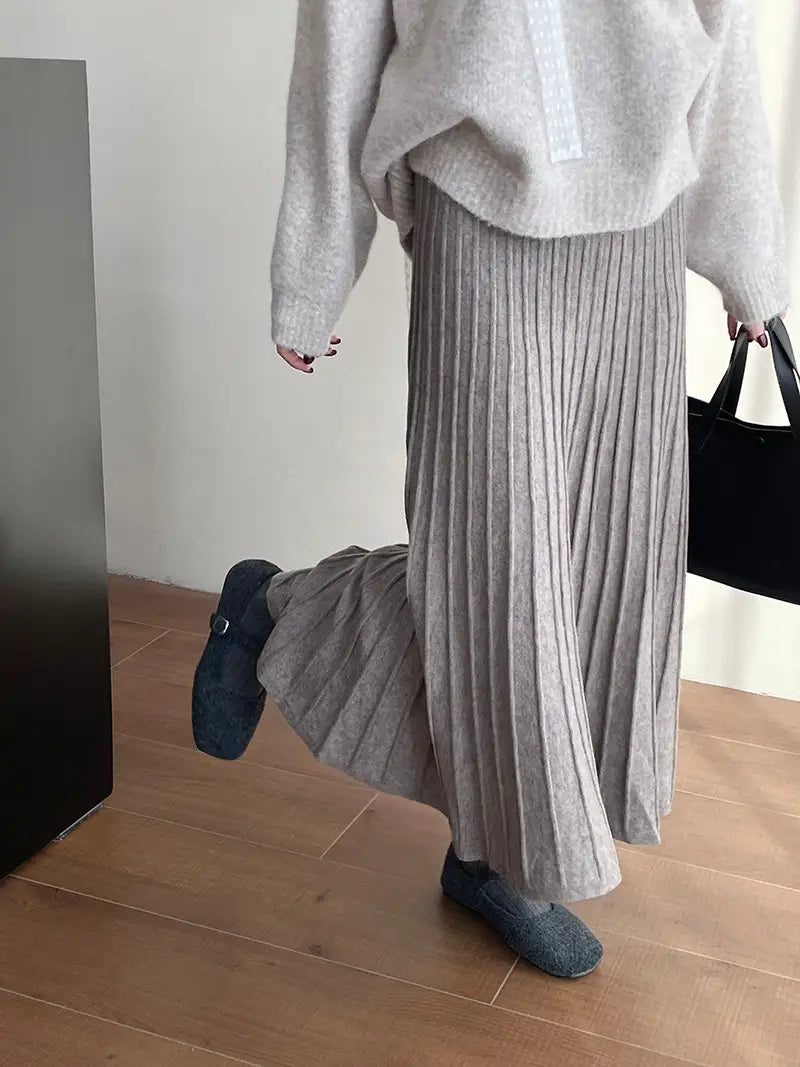 A soft light gray pleated midi skirt made of cozy knit fabric with a korean elastic waist knitted design.