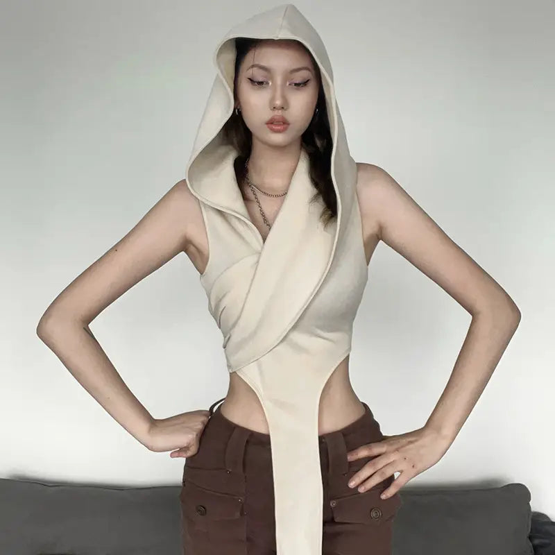 Cream stylish short crop hooded wraparound top featuring a cream-colored hooded sleeveless design with wraparound details and side cutouts, perfect for casual wear as a stylish short crop top.