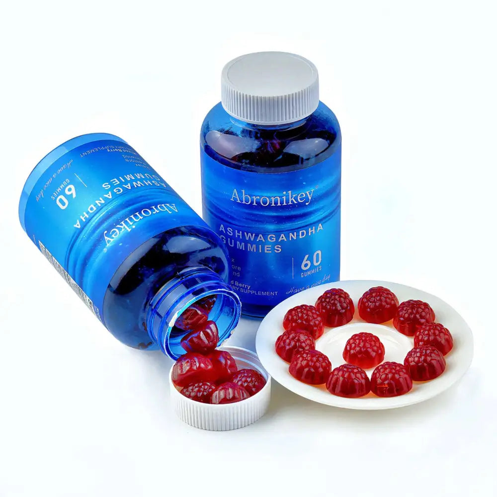 Blue plastic bottle of abronikey ashwagandha vitamin d gummy with white cap and raspberry-shaped gummies in a bowl