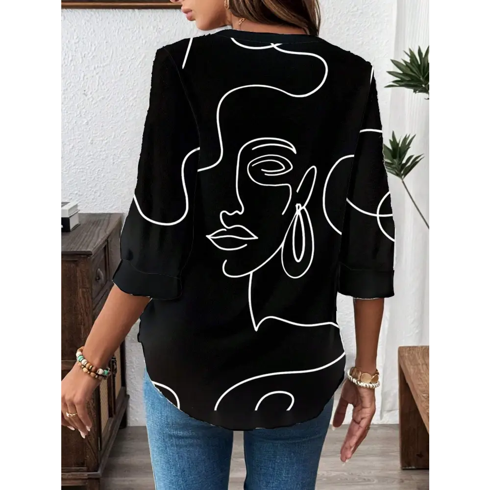 Black casual office blouse with abstract face pattern and three-quarter sleeve length featuring white line art design