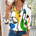 White blouse with bold abstract face pattern in yellow blue green and red on flowing fabric casual office blouse with sleeve length