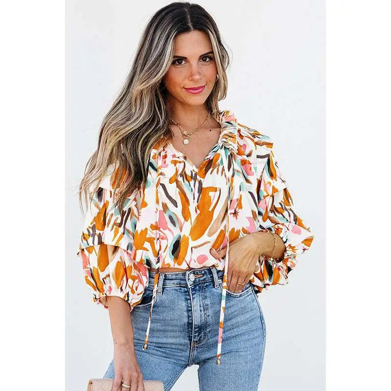 A woman wears a vibrant fashion colorblock printed chiffon shirt women with abstract floral orange and pink patterns