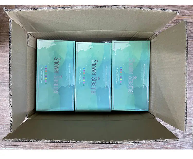 three teal-colored shower tablets in sleek rectangular boxes with minimalist design and subtle gradient finish for an 8 piece floral aromatherapy shower tablets set