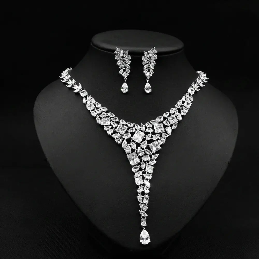 a dazzling silver-toned colorful zircon necklace set featuring a v-shaped design with cascading teardrop pendants and matching leaf-inspired earrings in the red crystal leaf zircon necklace set