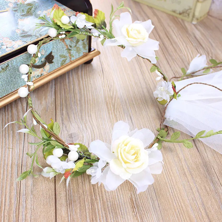 Handmade white rose bridal veil with an elegant white floral headband adorned with delicate artificial roses green leaves and small pearl-like beads.