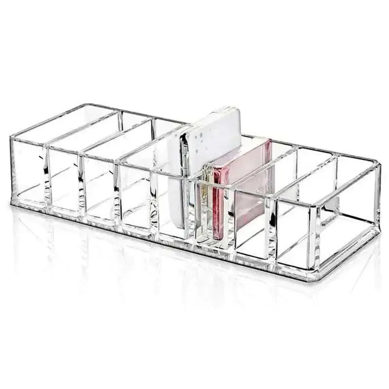 Clear acrylic makeup organizer with compartments holding multiple items including white phone and pink card