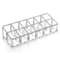 Clear acrylic makeup organizer with rectangular segmented design and compartments holding multiple cosmetic items
