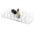 Clear acrylic makeup organizer with compartments holding multiple lipsticks including black and gold red tubes
