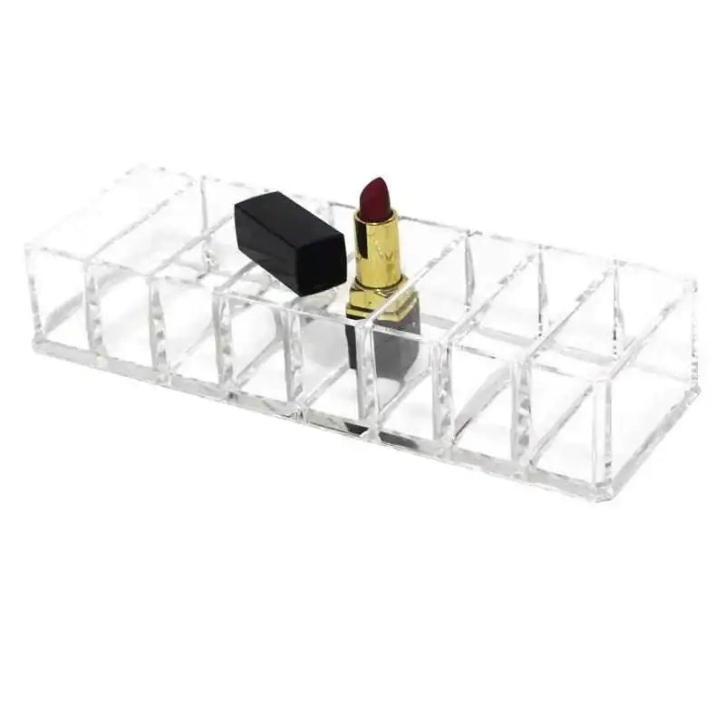 Clear acrylic makeup organizer with compartments holding multiple lipsticks including black and gold red tubes