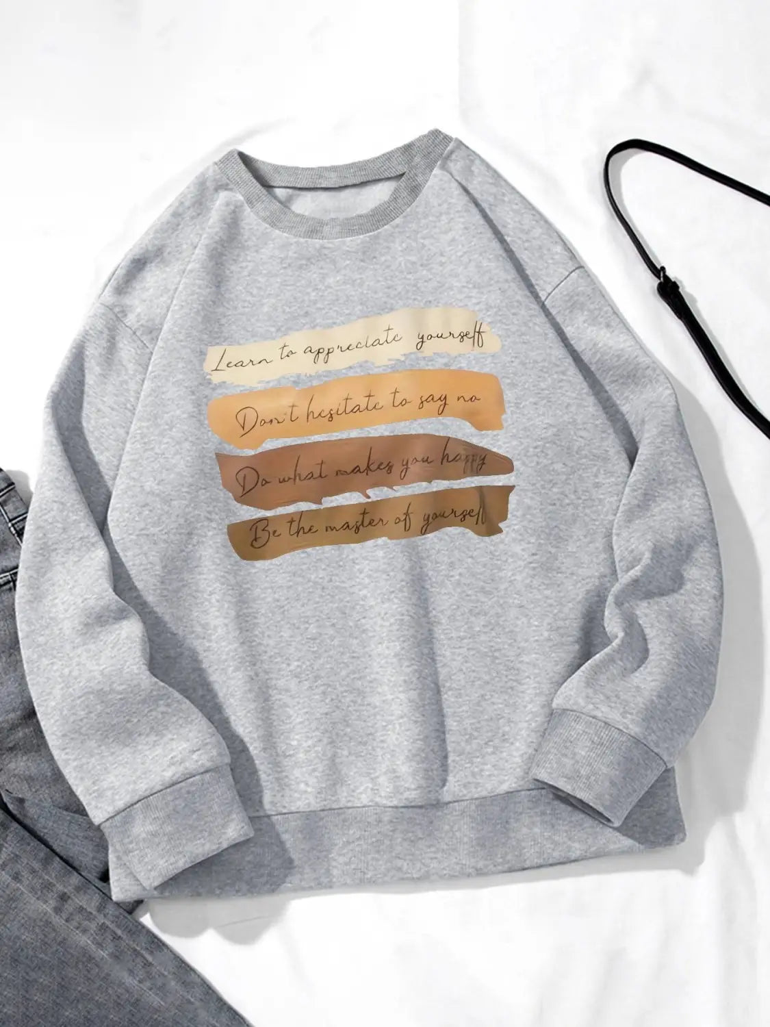 White oversized long sleeve sweatshirt in gray heathered solid colour with a motivational quote printed in brown and beige tones designed for daily wear.