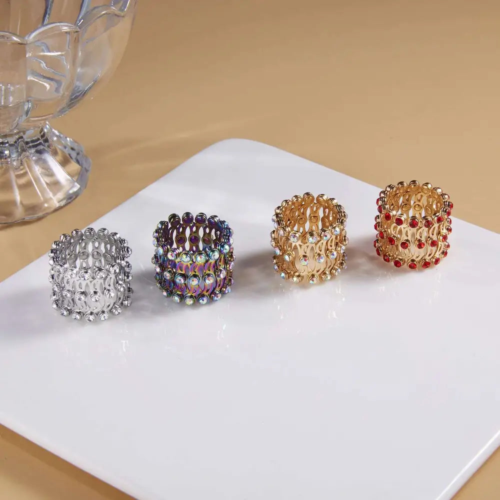 Adjustable rhinestone bracelet and fashion rings set featuring four expandable jeweled napkin rings in silver, iridescent, gold, and red