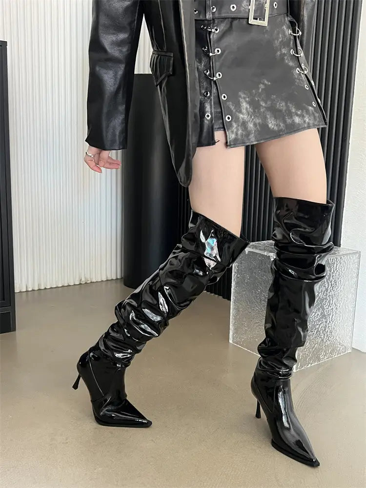 shiny black patent leather thigh high boots with a pointed toe and slender autumn stiletto heel in a heel pile style design