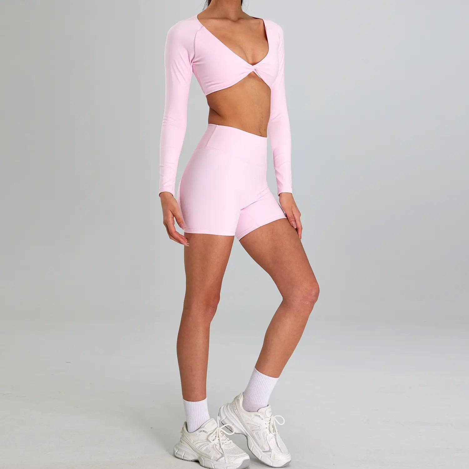 a soft pink long-sleeved crop top with a flattering v-neck and front tie detail from the maroon high waist suit outdoor running nude set designed for sports suit outdoor activities.