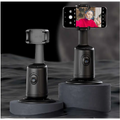 Black gimbal stabilizer with phone mount holding smartphone displaying selfie featuring smart face tracking technology