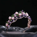 A wedding bridal tiara with alloy crystal flowers pink pearls purple crystals and green leaf accents on rose gold base