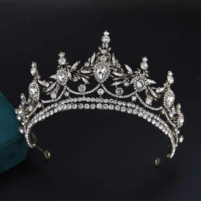 An ornate silver alloy electroplate crown with intricate leaf and floral designs featuring clear crystals korean style