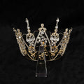 A sparkling gold alloy electroplate crown korean style with clear crystals and intricate leaf detailing on a transparent stand