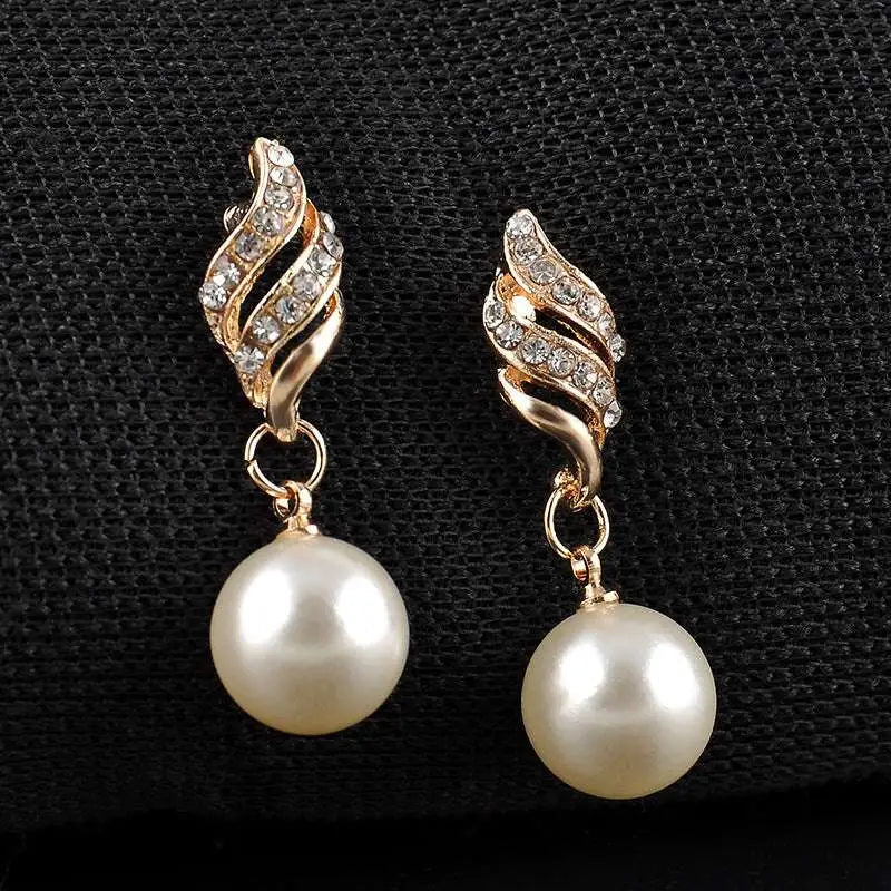 Gold-toned wing-shaped earrings with clear crystals and cream pearls from american wedding jewelry pearl set