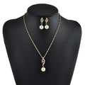 Gold-toned american wedding jewelry necklace with twisted crystal pendant and matching pearl drop earrings on black mannequin