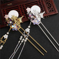 Two ornate costume hairpin adorned with gold and silver tones featuring floral discs with pearls and tassel accents