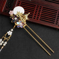 Elegant gold ancient costume hairpin adorned with white disc, iridescent gemstones, pearls, and delicate floral tassel accessories