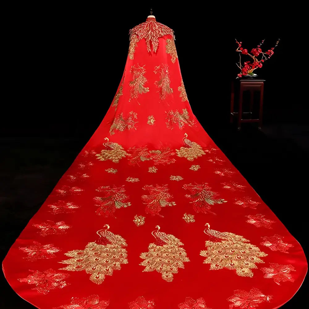 A vibrant red ancient xiuhe dress bridal cape with intricate gold peacock embroidery displayed on a mannequin
