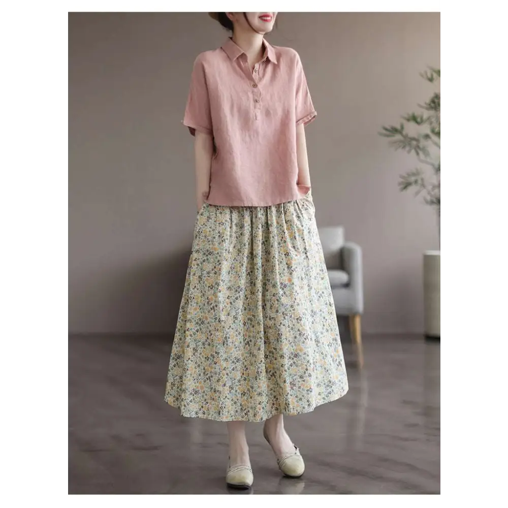 A soft pink short-sleeved linen shirt with classic collar and button front paired with artistic floral washed cotton midi skirt