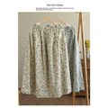 Artistic floral washed cotton midi skirt in pale yellow and green with delicate floral pattern on wooden hanger