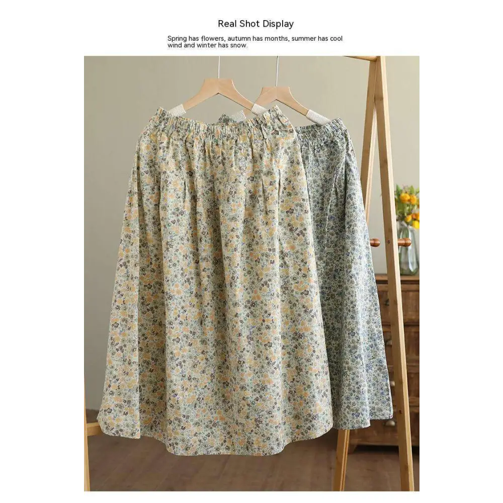 Artistic floral washed cotton midi skirt in pale yellow and green with delicate floral pattern on wooden hanger