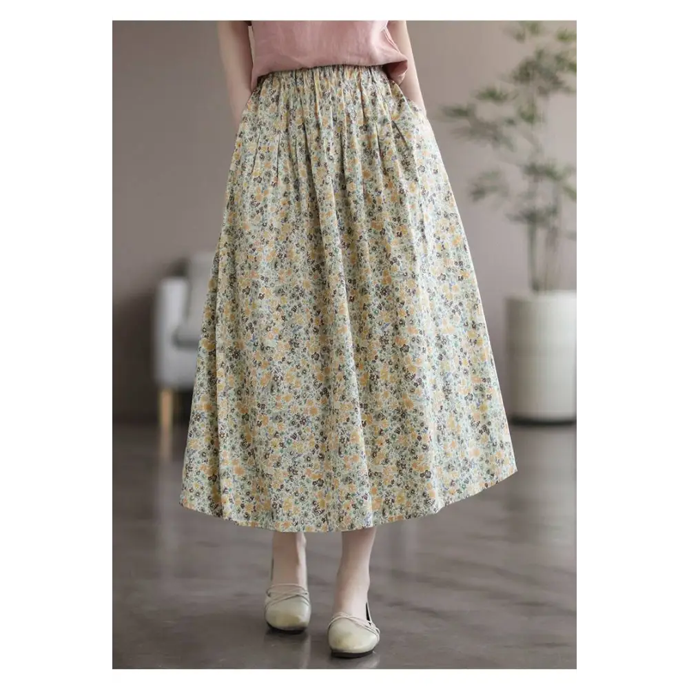 Artistic floral washed cotton midi skirt with delicate floral pattern featuring yellow and green blossoms on pale background