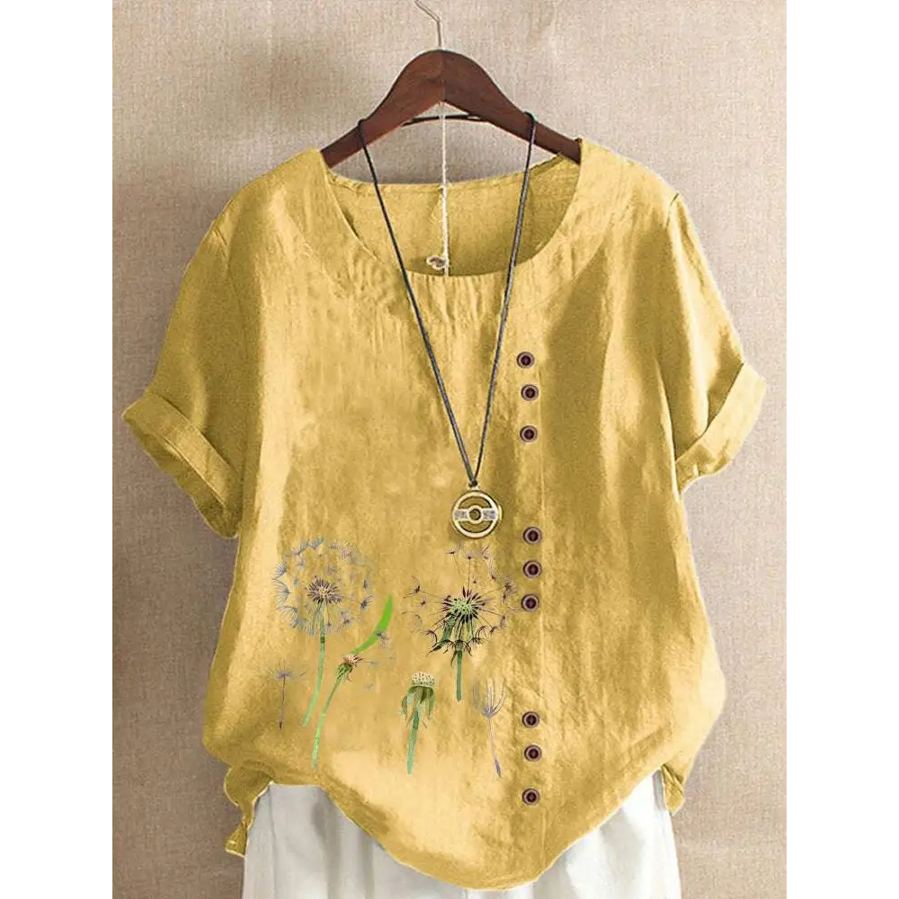 A soft yellow linen printed casual top with embroidered dandelion designs and a row of brown buttons down the front