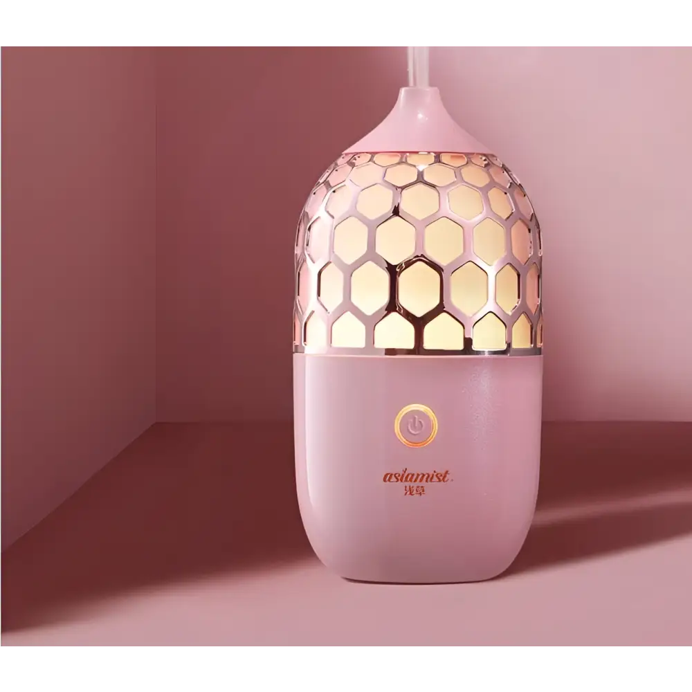 Asakusa pink aroma diffuser with pink honeycomb-patterned ceramic and gold accents releasing gentle mist