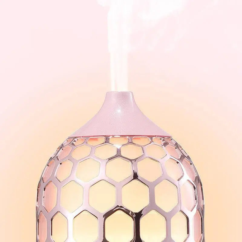 Asakusa pink aroma diffuser in rose gold with pink honeycomb-patterned design emitting gentle mist