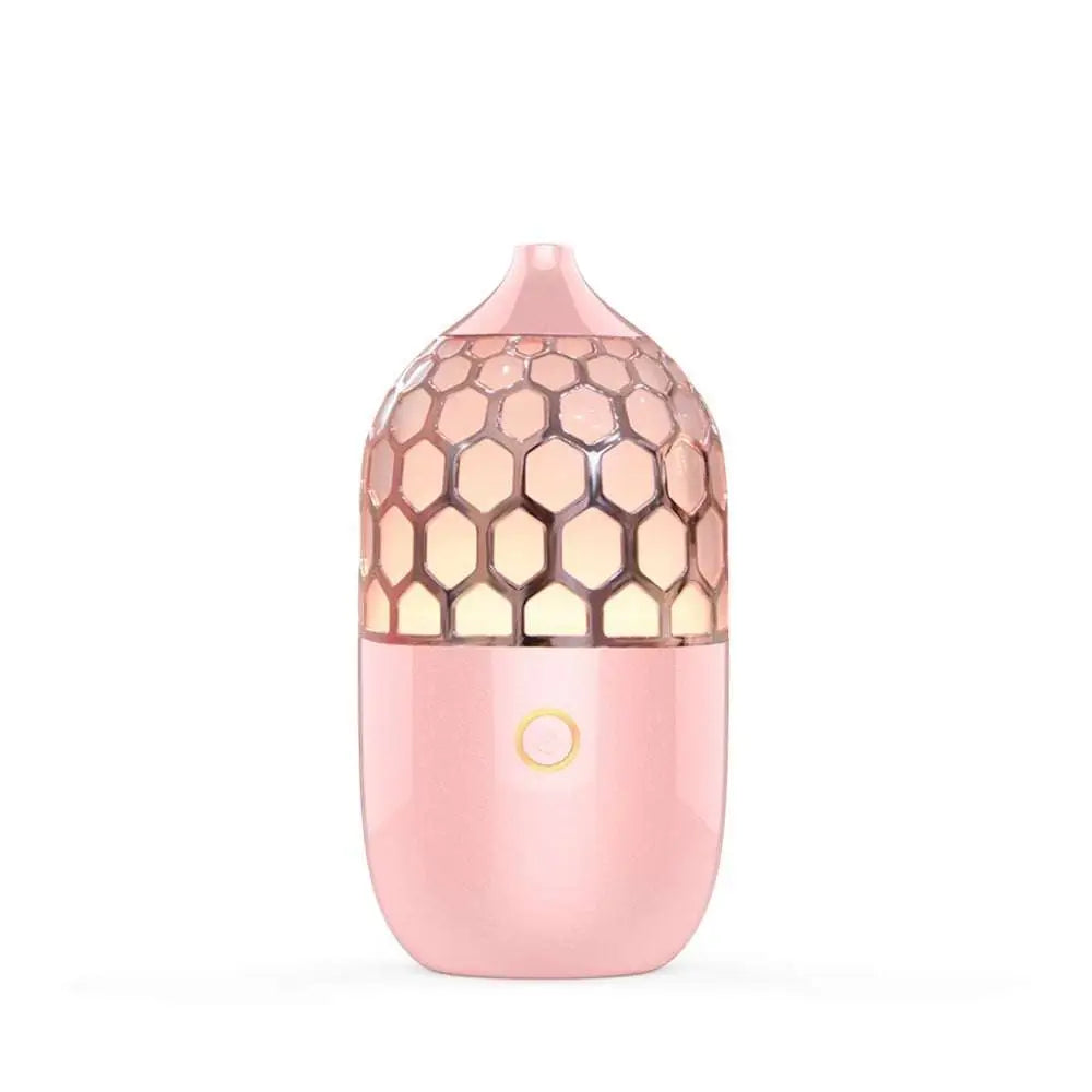 Asakusa pink aroma diffuser with pink honeycomb-patterned glossy finish and gold accent button releasing gentle mist
