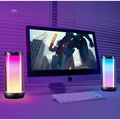 A sleek cylindrical led ambient light gaming bluetooth speaker with a translucent body and vibrant gradient lighting