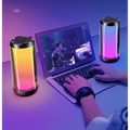 Two cylindrical led ambient light gaming bluetooth speakers with black tops glowing yellow to pink and purple colors