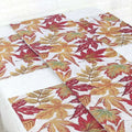Autumn maple leaf decor table runner with woven texture featuring vibrant red orange and yellow leaves on white background