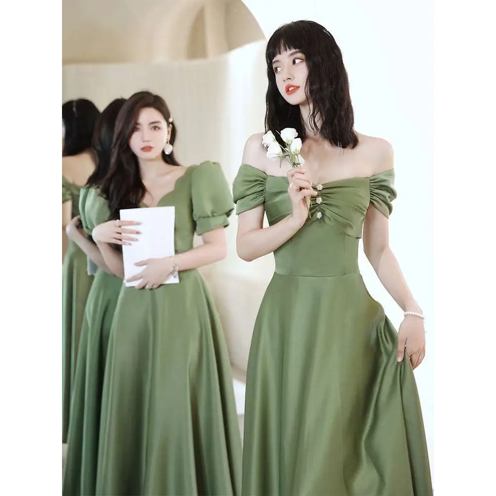 A woman wears an avocado green sisters satin midi dress with puffed sleeves and a gathered bodice