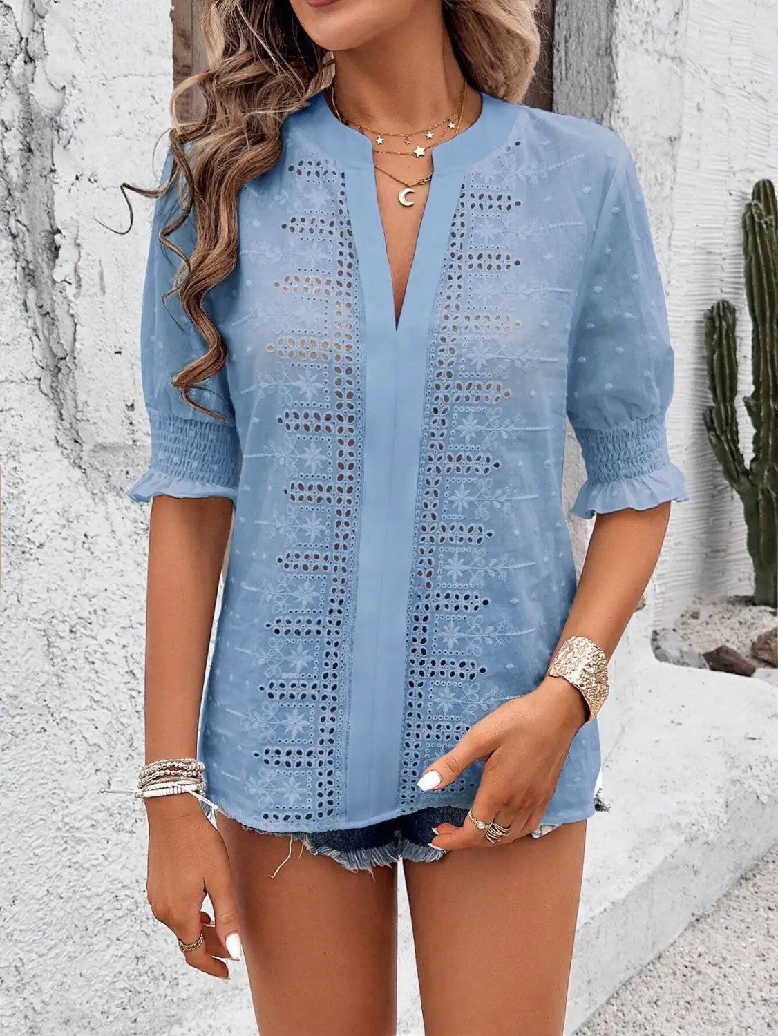 Light blue semi-sheer blouse with intricate eyelet embroidery and ruffled puff sleeve featuring hollow hair ball detailing.