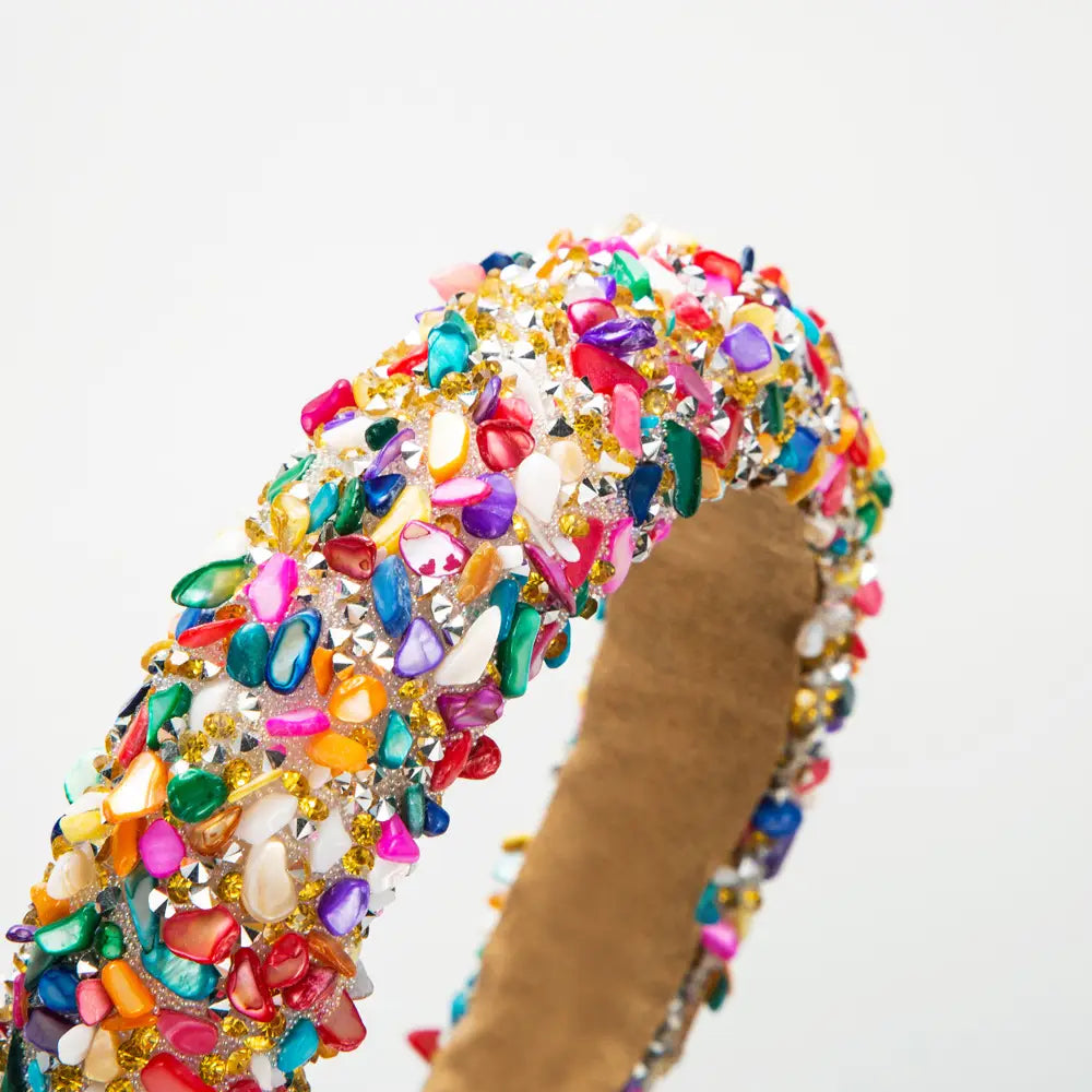 a vibrant baroque colorful headband featuring a dense array of multicolored gemstones and crystals in various shapes and sizes