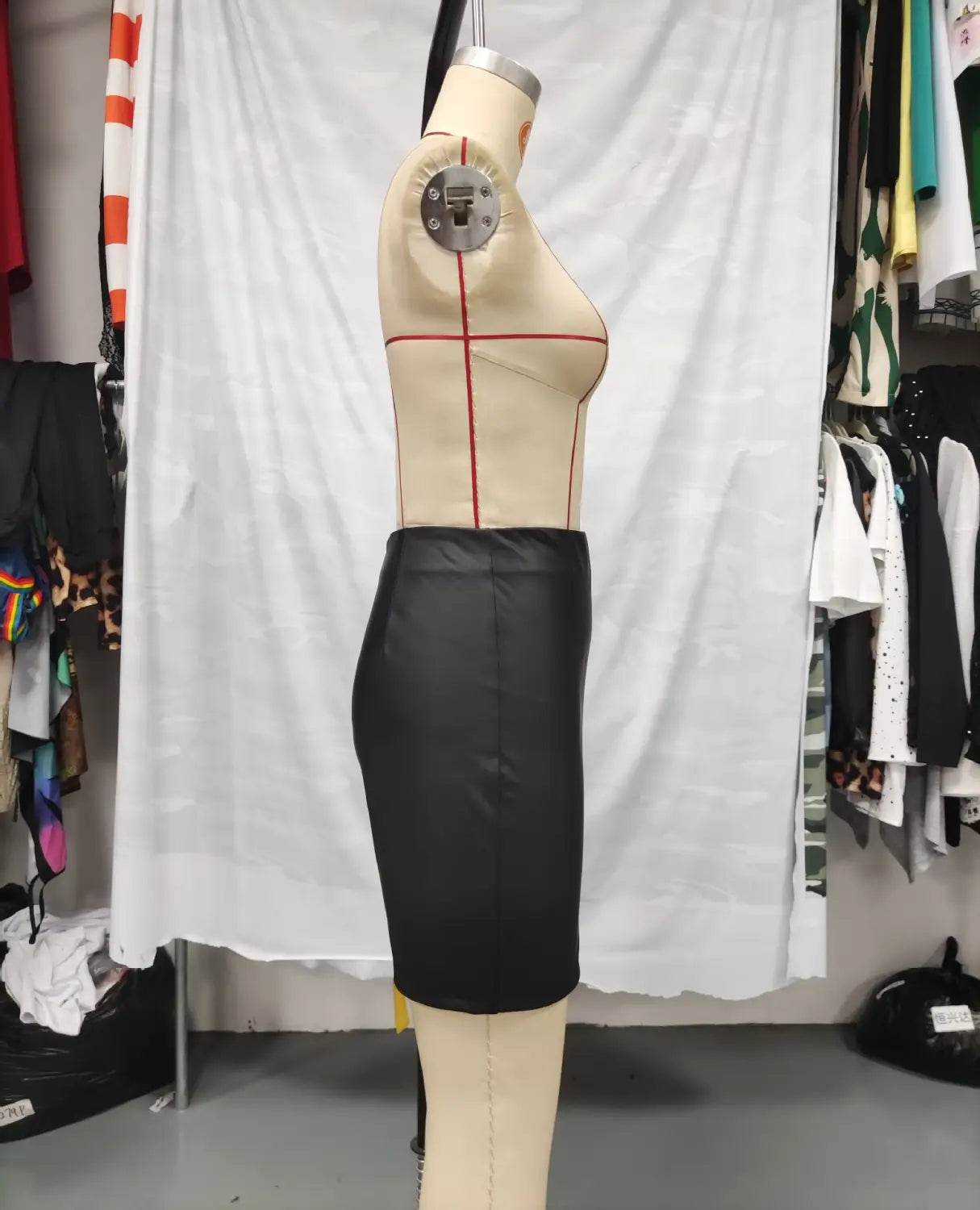 black high waist tight pu leather mini skirt displayed on a dress form with ruched detailing