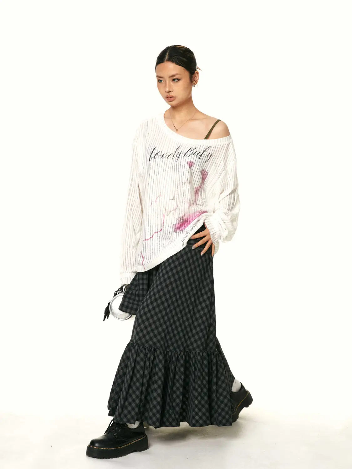white off-the-shoulder knit top with freaky baby text and pink abstract graphic paired with a retro easy matching ruffled plaid fishtail skirt.
